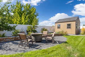 View of patio / terrace with a shed and a fire pit