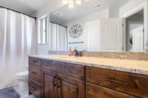 Bathroom with vanity, toilet, and tile patterned floors