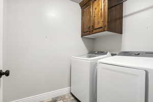 Clothes washing area with washer and clothes dryer and cabinets