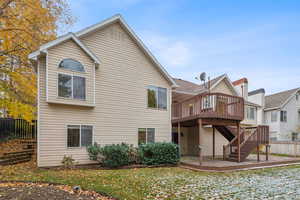 Back of property a Trex deck with stairs down to patio area and backyard