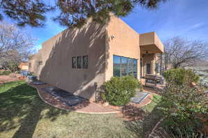 View of property exterior with a lawn, ceiling fan, and a patio area