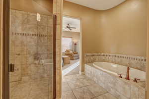 Bathroom with tile patterned flooring, ceiling fan, and separate shower and tub