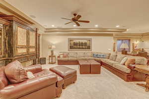 Carpeted living room with ceiling fan