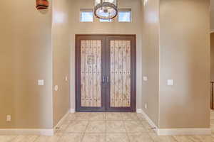 Tiled entrance foyer featuring french doors