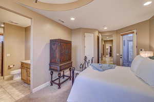 Bedroom with connected bathroom and light tile patterned floors