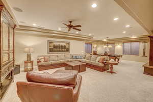 Carpeted living room with ceiling fan, billiards, and a tray ceiling