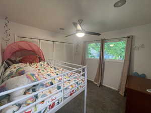 Carpeted bedroom featuring a closet and ceiling fan