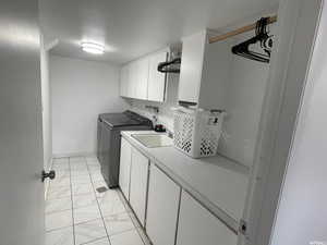 Laundry area with cabinets, sink, and washing machine and clothes dryer