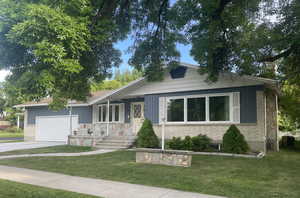 Ranch-style house featuring a front yard and a garage