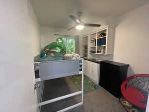 Carpeted bedroom featuring ceiling fan