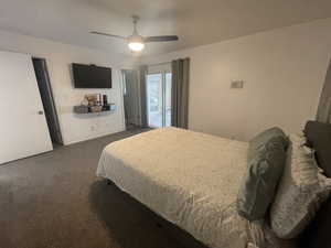 Carpeted bedroom featuring ceiling fan and access to exterior