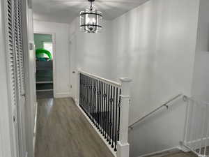 Stairs featuring a notable chandelier and hardwood / wood-style flooring