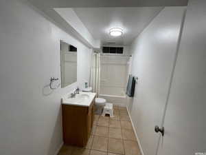 Full bathroom with vanity, tile patterned flooring, toilet, and shower / tub combo with curtain