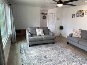 Living room with ceiling fan, plenty of natural light, and wood-type flooring