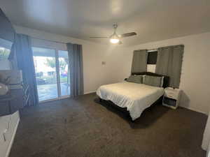 Carpeted bedroom featuring ceiling fan and access to exterior