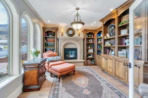 Living area featuring light wood-type flooring and ornamental molding