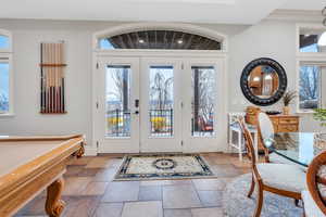 Entryway featuring a healthy amount of sunlight, billiards, and french doors