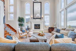 Living room featuring wood-type flooring, a notable chandelier, and a towering ceiling