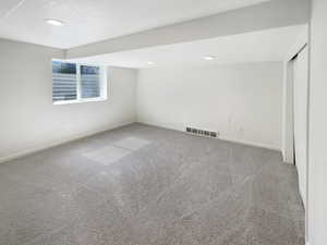 Carpeted empty room featuring a textured ceiling