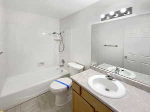 Full bathroom featuring shower / bathtub combination, tile patterned flooring, vanity, and toilet