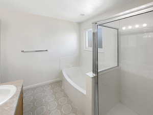 Bathroom featuring vanity, plus walk in shower, and tile patterned flooring