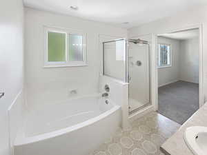 Bathroom with tile patterned flooring, vanity, and separate shower and tub