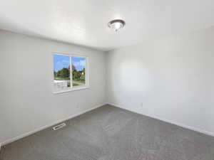 Spare room featuring carpet floors and a textured ceiling