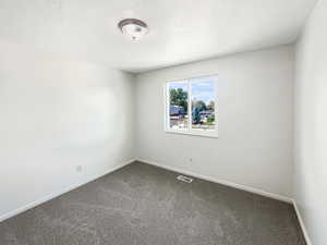 Carpeted empty room with a textured ceiling