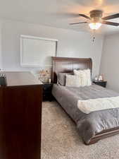 Bedroom featuring carpet, ceiling fan, and a textured ceiling