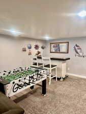 Game room featuring indoor bar and carpet floors