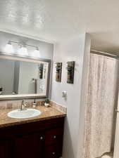 Bathroom with a textured ceiling and vanity