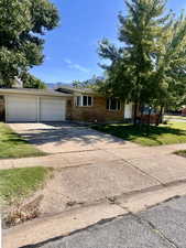 View of front of property featuring a garage and a front lawn