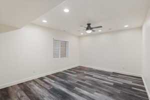 Empty room featuring ceiling fan and dark hardwood / wood-style floors