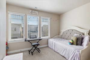 Bedroom featuring multiple windows, a textured ceiling, and light colored carpet