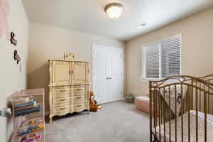 Bedroom with a textured ceiling, a closet, and carpet