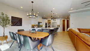 Dining room featuring light wood-type flooring, sink, and a notable chandelier