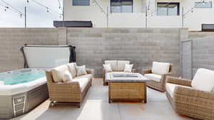 View of patio with an outdoor living space with a fire pit and a hot tub