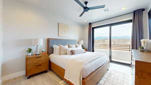 Bedroom featuring light hardwood / wood-style flooring, a mountain view, ceiling fan, and access to exterior