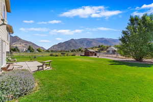 View of yard featuring a mountain view, a patio area, and a shed