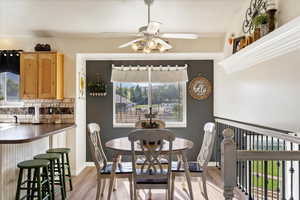 Dining room with light hardwood / wood-style flooring, ceiling fan, and plenty of natural light