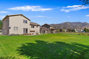 Rear view of house featuring a mountain view and a yard