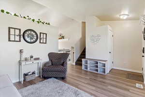 Sitting room featuring lofted ceiling and hardwood / wood-style floors