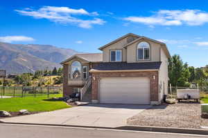 Front of property with a mountain view, a front lawn, and a garage