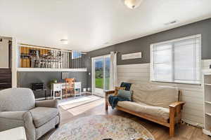 Living room with wood walls and hardwood / wood-style floors