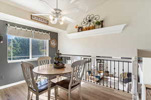 Dining area with wood-type flooring, vaulted ceiling, and ceiling fan