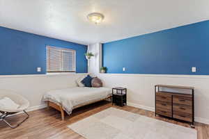 Bedroom featuring light wood-type flooring and a textured ceiling