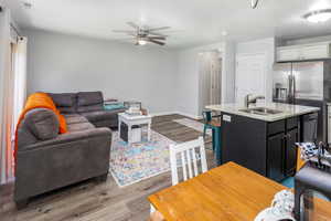 Living room featuring ceiling fan, light hardwood / wood-style flooring, and sink