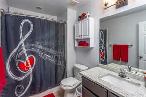 Bathroom featuring vanity, toilet, a textured ceiling, tile patterned flooring, and a shower with shower curtain