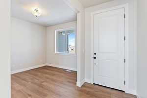 Foyer featuring light wood-type flooring and a textured ceiling