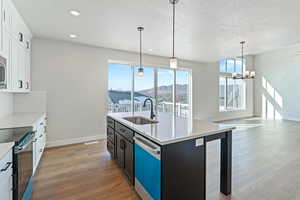 Kitchen with pendant lighting, white cabinets, appliances with stainless steel finishes, sink, and a mountain view